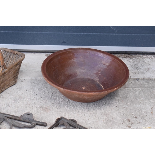 316 - A mixed collection of items to include a large earthenware bowl, wicker basket, cast iron wall mount... 