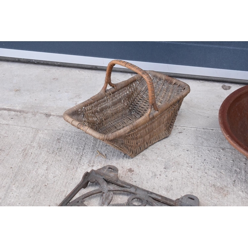 316 - A mixed collection of items to include a large earthenware bowl, wicker basket, cast iron wall mount... 