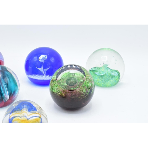 32 - A collection of Caithness glass paperweights to include Pebble, Scimitar, Nebula, Moonlight Dancer, ... 