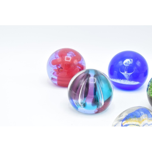 32 - A collection of Caithness glass paperweights to include Pebble, Scimitar, Nebula, Moonlight Dancer, ... 