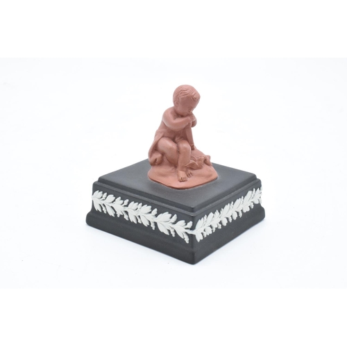 80 - A Wedgwood model of a cherub finial in Terracotta colours mounted on a black jasperware square base ... 