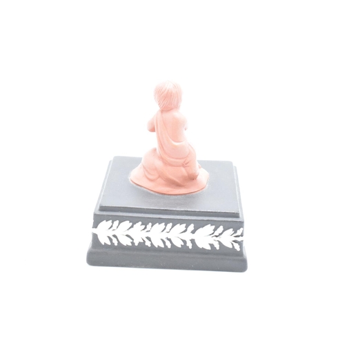 80 - A Wedgwood model of a cherub finial in Terracotta colours mounted on a black jasperware square base ... 