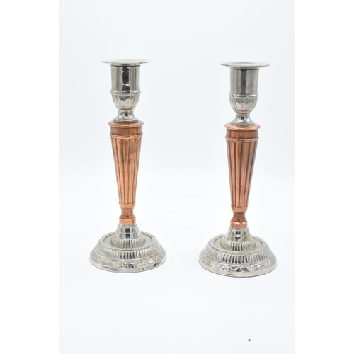 181 - A pair of silver plate and copper candlesticks with a column effect body. 24cm tall.