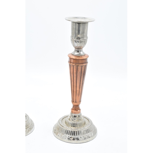 181 - A pair of silver plate and copper candlesticks with a column effect body. 24cm tall.