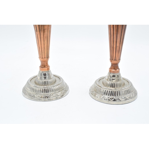 181 - A pair of silver plate and copper candlesticks with a column effect body. 24cm tall.