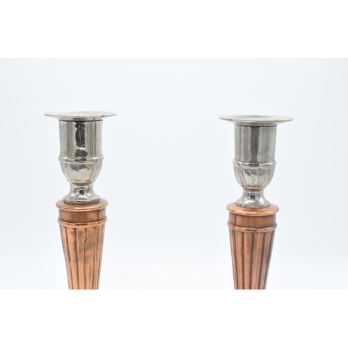 181 - A pair of silver plate and copper candlesticks with a column effect body. 24cm tall.