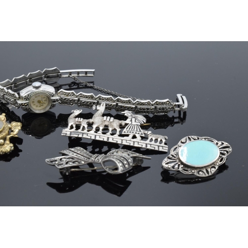 230E - A collection of items to include silver and marcasite brooches, a marcasite wrist watch and a pinch ... 