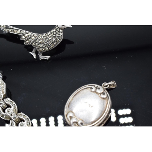 230F - A collection of silver and silver-coloured items to include brooches, a ring and a stainless steel m... 