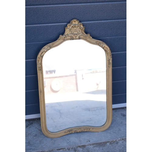 322 - An early 20th century gilt-effect ornate framed mirror. 83cm tall. A crack to the top ornate section... 