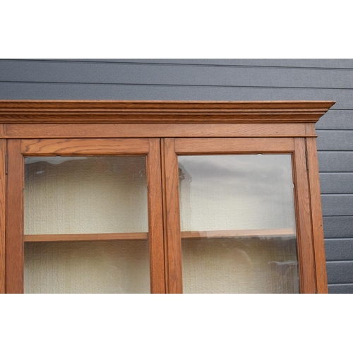 331 - Edwardian/ 20th century golden oak book case with glass doors. In good condition with age related we... 