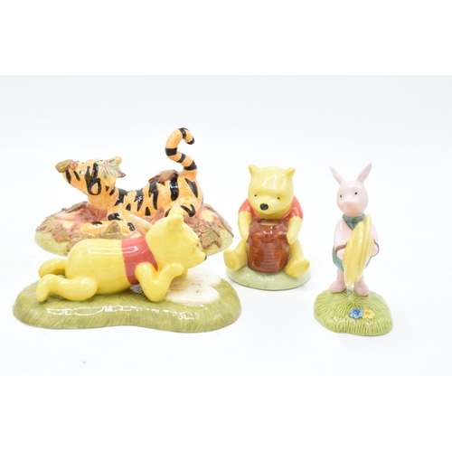 115 - A collection of Royal Doulton Winnie The Pooh figures to include All the flowers are waking up, Love... 