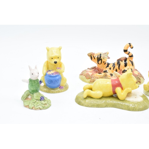 115 - A collection of Royal Doulton Winnie The Pooh figures to include All the flowers are waking up, Love... 