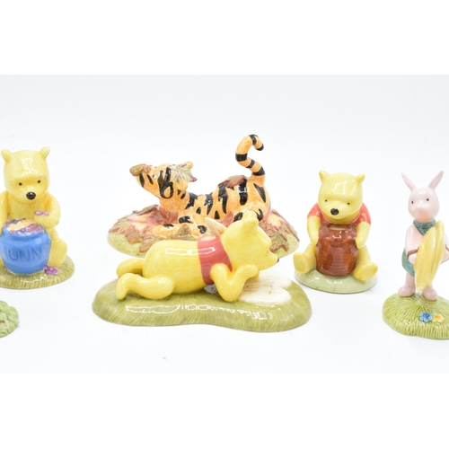 115 - A collection of Royal Doulton Winnie The Pooh figures to include All the flowers are waking up, Love... 