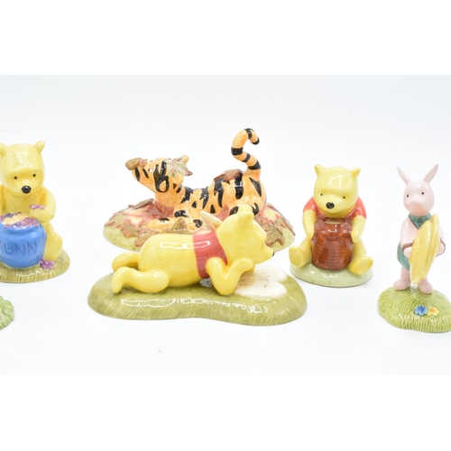 115 - A collection of Royal Doulton Winnie The Pooh figures to include All the flowers are waking up, Love... 