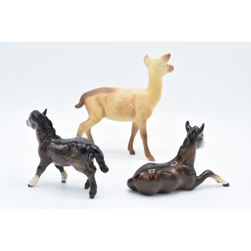 166 - Beswick items to include a brown lying down foal 915, a brown Shetland and a matte doe (3). In good ... 