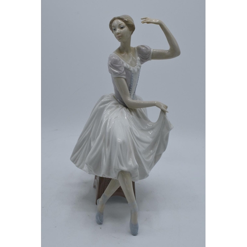 189 - A large Lladro figurine of a ballerina perched on a stool. A-21E. 29cm tall. In good condition with ... 