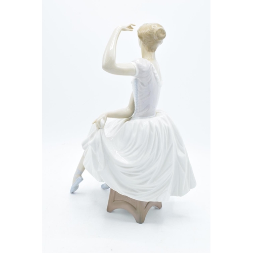 189 - A large Lladro figurine of a ballerina perched on a stool. A-21E. 29cm tall. In good condition with ... 