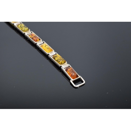 220 - A silver ladies bracelet set with different shades of amber, 18cm in length. 9.8 grams gross weight.... 