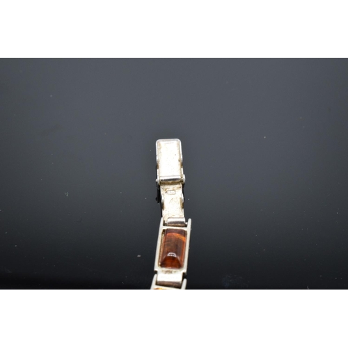 220 - A silver ladies bracelet set with different shades of amber, 18cm in length. 9.8 grams gross weight.... 