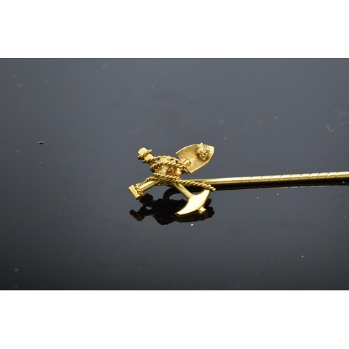 229A - A 9ct gold stick pin in the form of a miner's shovel and pick axe. Tests as 9ct gold. 2.1 grams. 6.5... 