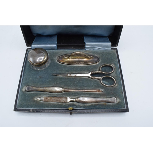 234 - A cased silver travelling manicure set to include scissors, nail file, lidded pot etc. Birmingham 19... 