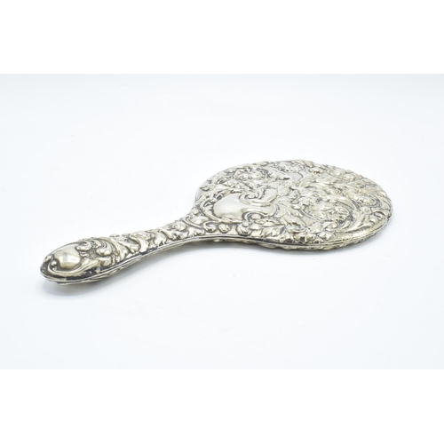 239 - An ornate embossed hand mirror, assumed silver plate.