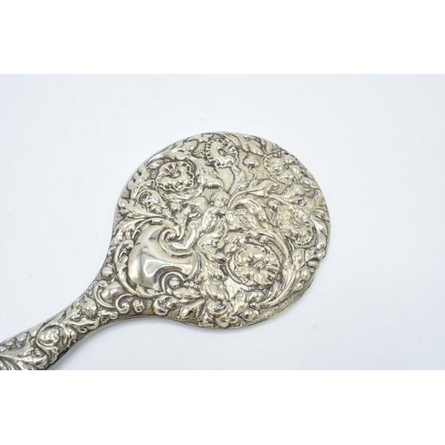 239 - An ornate embossed hand mirror, assumed silver plate.