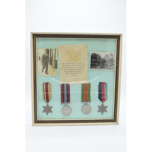 255 - A framed collection of militaria to include photos of soldiers, a message from the Under-Secretary o... 