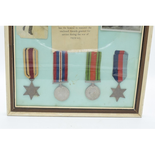 255 - A framed collection of militaria to include photos of soldiers, a message from the Under-Secretary o... 