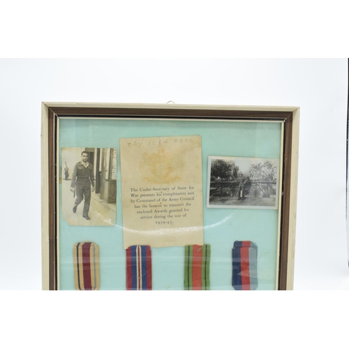 255 - A framed collection of militaria to include photos of soldiers, a message from the Under-Secretary o... 