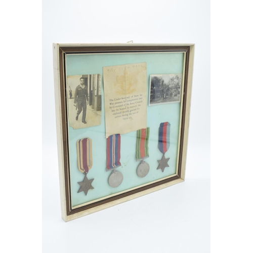 255 - A framed collection of militaria to include photos of soldiers, a message from the Under-Secretary o... 