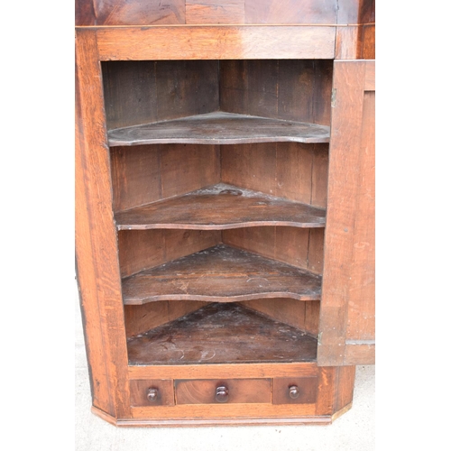 354 - A Georgian period oak corner cupboard with raised sections and a single drawer. 128cm tall, 82cm at ... 