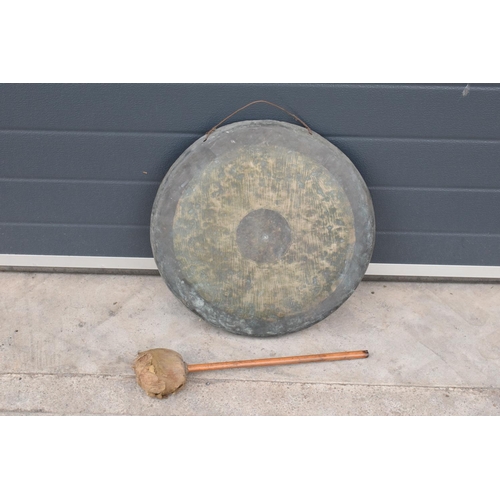 233 - A large hanging gong with striker. 48cm diameter