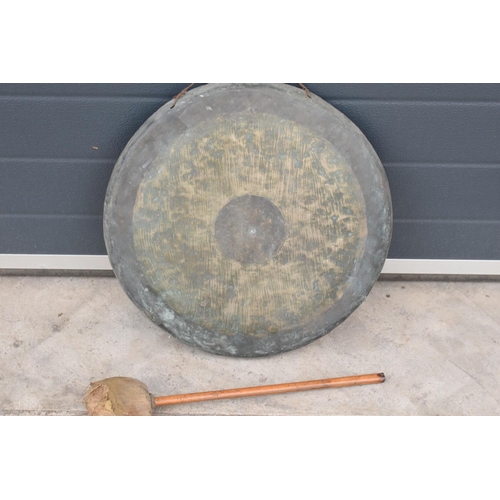 233 - A large hanging gong with striker. 48cm diameter