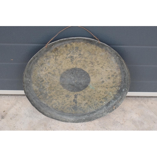 233 - A large hanging gong with striker. 48cm diameter