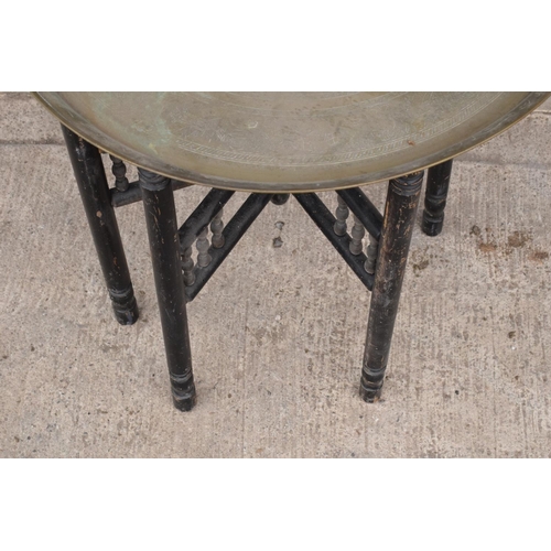 242 - A 20th century folding brass and wooden Indian or Indian style table. 60cm tall. In functional condi... 