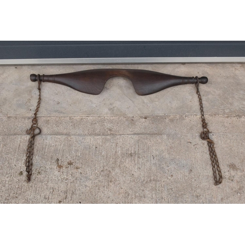 246 - An antique farmer's wooden yoke complete with chains and hooks. 90cm wide. In good functional condit... 