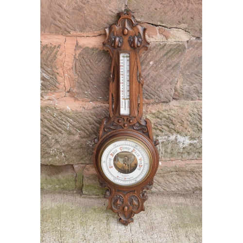 247 - A late Victorian/ Edwardian arts and crafts style carved aneroid barometer by James Lucking and Co, ... 