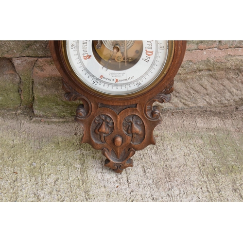 247 - A late Victorian/ Edwardian arts and crafts style carved aneroid barometer by James Lucking and Co, ... 