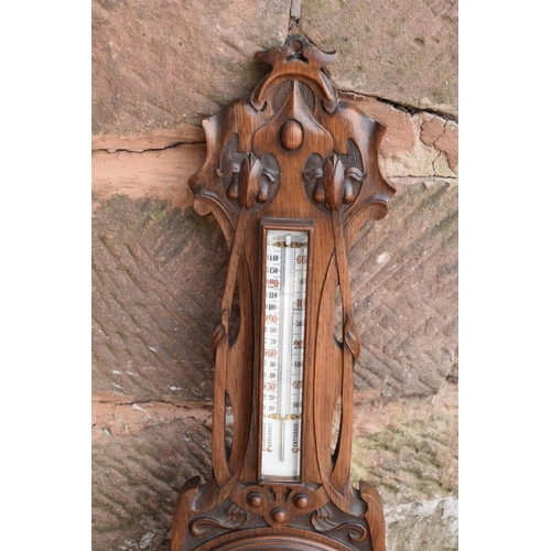 247 - A late Victorian/ Edwardian arts and crafts style carved aneroid barometer by James Lucking and Co, ... 