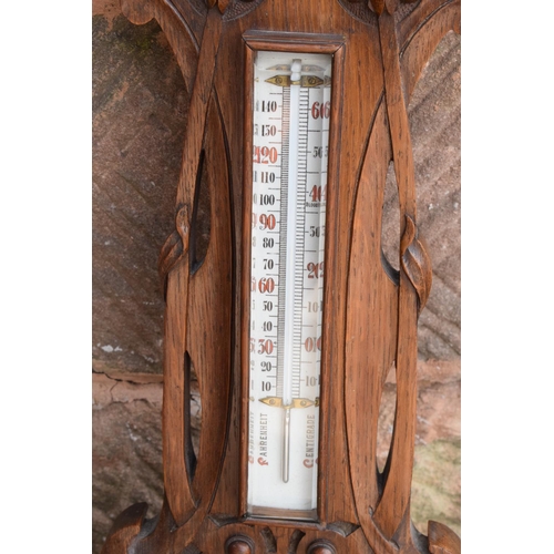 247 - A late Victorian/ Edwardian arts and crafts style carved aneroid barometer by James Lucking and Co, ... 