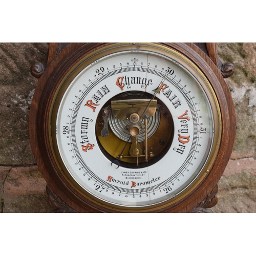 247 - A late Victorian/ Edwardian arts and crafts style carved aneroid barometer by James Lucking and Co, ... 