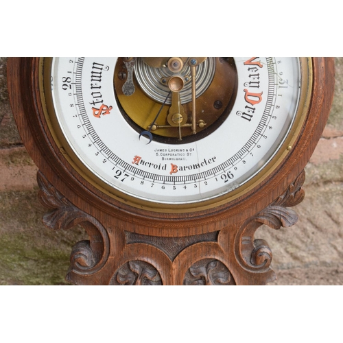 247 - A late Victorian/ Edwardian arts and crafts style carved aneroid barometer by James Lucking and Co, ... 