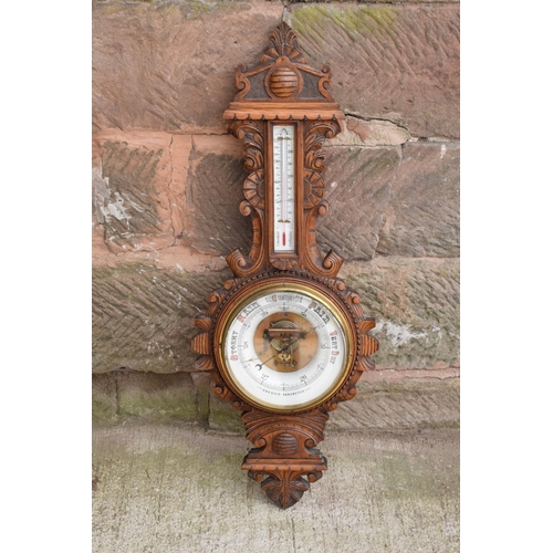 248 - A late Victorian/ Edwardian arts and crafts style carved aneroid barometer. 109cm tall. There are so... 