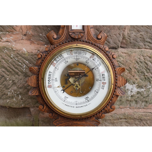 248 - A late Victorian/ Edwardian arts and crafts style carved aneroid barometer. 109cm tall. There are so... 