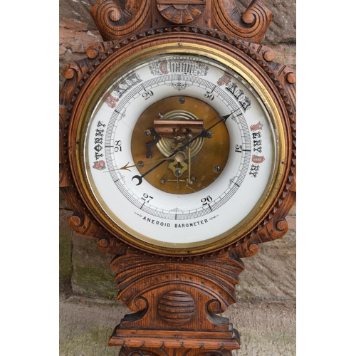 248 - A late Victorian/ Edwardian arts and crafts style carved aneroid barometer. 109cm tall. There are so... 