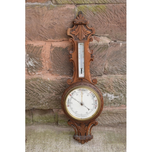 249 - A late Victorian/ Edwardian arts and crafts style carved aneroid barometer. 105cm tall. There are so... 