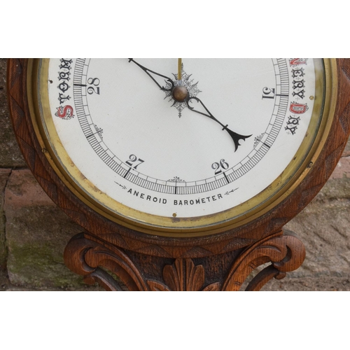 249 - A late Victorian/ Edwardian arts and crafts style carved aneroid barometer. 105cm tall. There are so... 