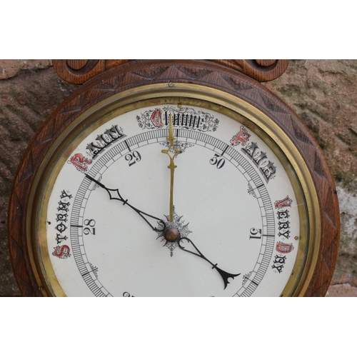 249 - A late Victorian/ Edwardian arts and crafts style carved aneroid barometer. 105cm tall. There are so... 