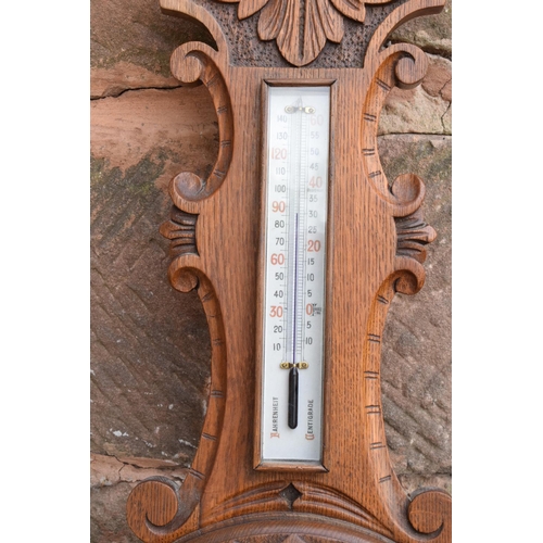 249 - A late Victorian/ Edwardian arts and crafts style carved aneroid barometer. 105cm tall. There are so... 